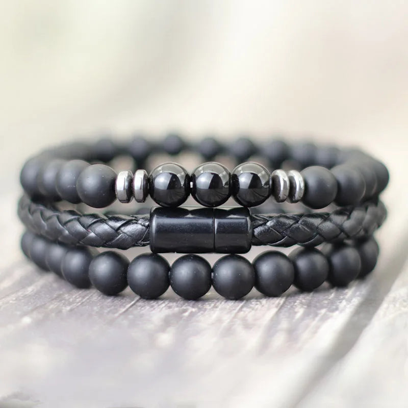 Stack of black beaded bracelets on a light wooden surface