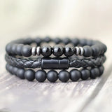 Stack of black beaded bracelets on a light wooden surface