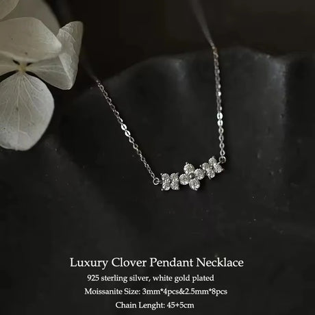 Luxury clover pendant necklace with white gold plating on a dark background