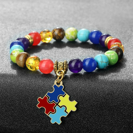 Colorful beaded bracelet with a puzzle piece charm on a gray background