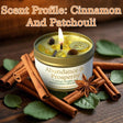 Candle with cinnamon and patchouli scents on a wooden surface with cinnamon sticks and leaves.