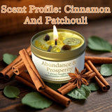 Candle with cinnamon and patchouli scents on a wooden surface with cinnamon sticks and leaves.
