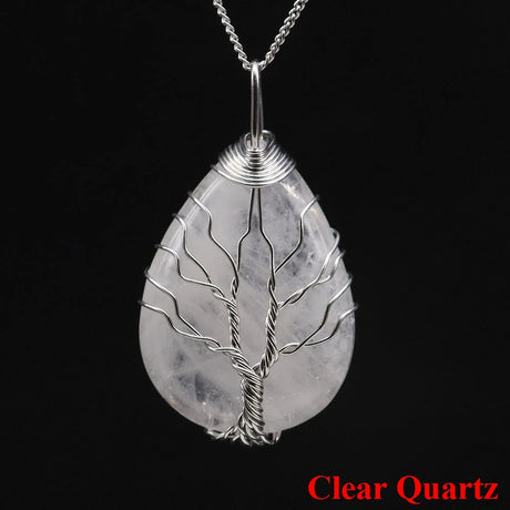Clear quartz tree of life pendant on a black background with 'Clear Quartz' text.