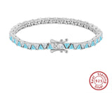 Silver bracelet with blue gemstones on a white background, featuring Orsa Jewels branding.