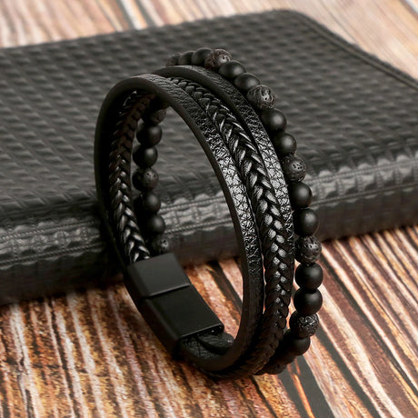 Black leather and beaded bracelet on a textured surface