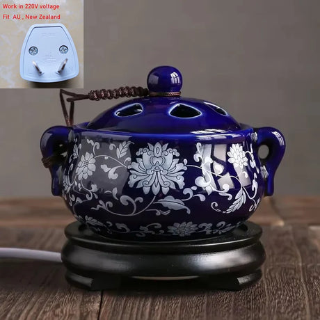 Blue ceramic incense burner with floral patterns on a wooden surface, with an inset of a power adapter.