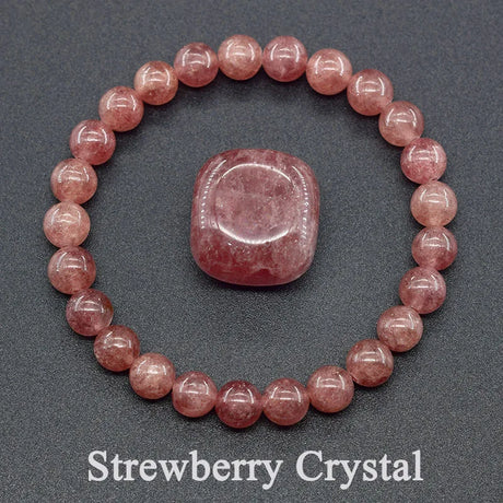 Strawberry crystal bracelet and stone on a gray background