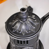 Close-up of a decorative metal coffee grinder with intricate design.