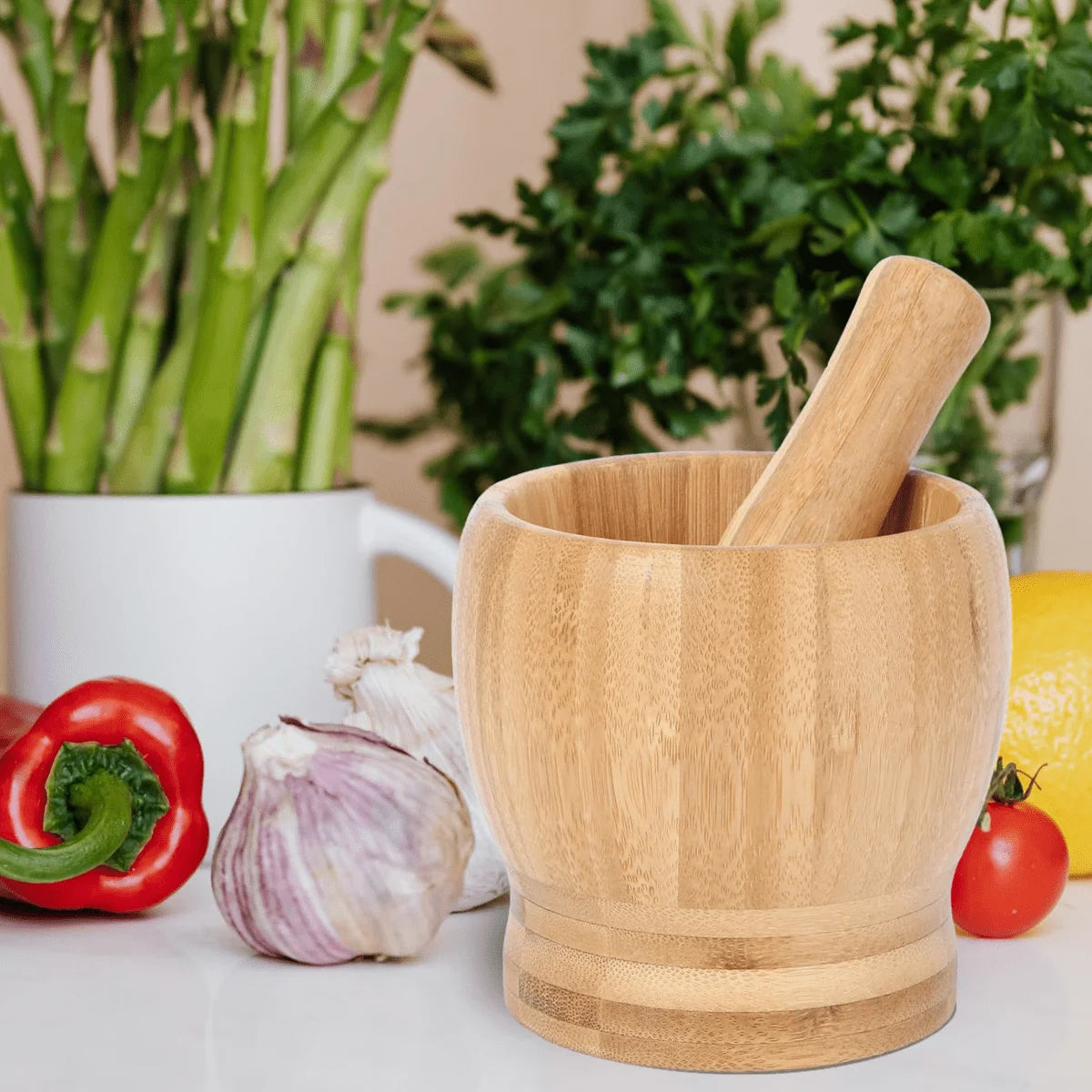 Wooden mortar and pestle with vegetables and plants in the background