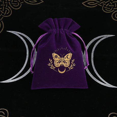 Purple drawstring bag with gold butterfly design on a black background with wiccan symbols.