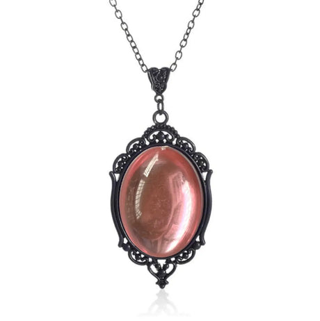 Necklace with a pink oval stone in an ornate black frame on a white background