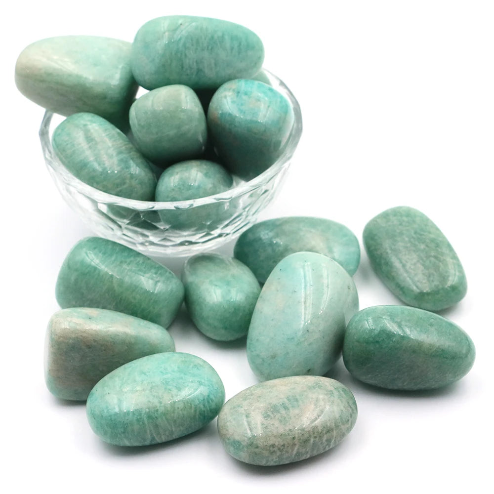 Turquoise stones with a clear glass bowl on a white background