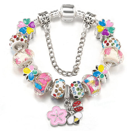 Colorful charm bracelet with floral and butterfly designs on a white background