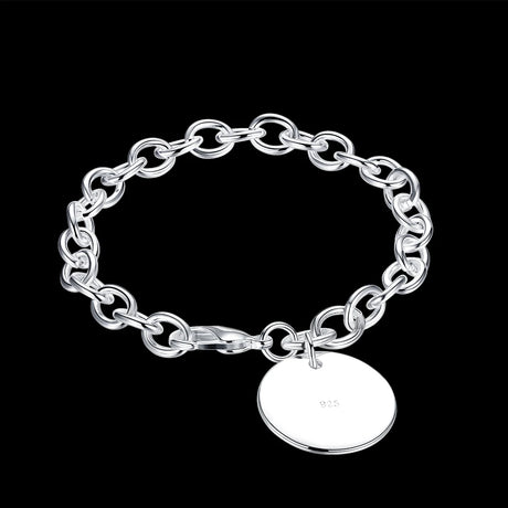Silver chain bracelet with a round tag on a black background