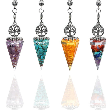 Set of four chakra stone pendulums with tree of life design on a white background