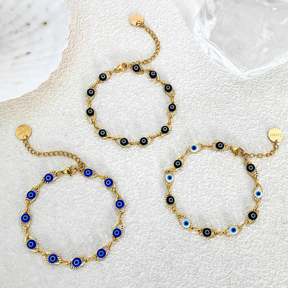 Gold bracelets with blue and black beads on a white background