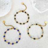Gold bracelets with blue and black beads on a white background