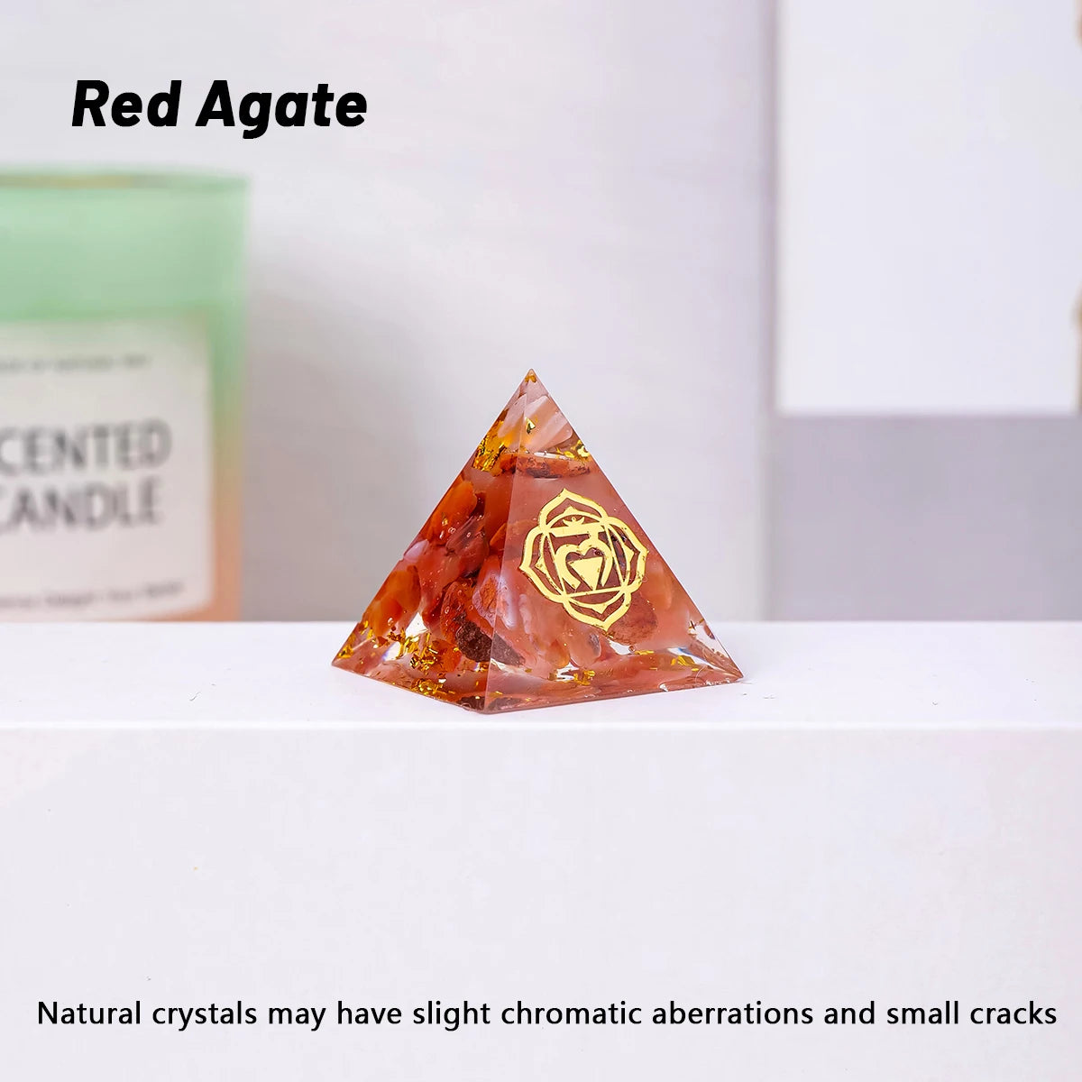Red Agate pyramid crystal on a white surface with a blurred background