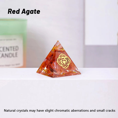 Red Agate pyramid crystal on a white surface with a blurred background
