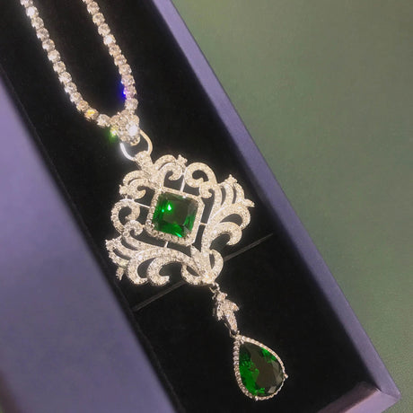 Jewelry necklace with green gemstones on a black background