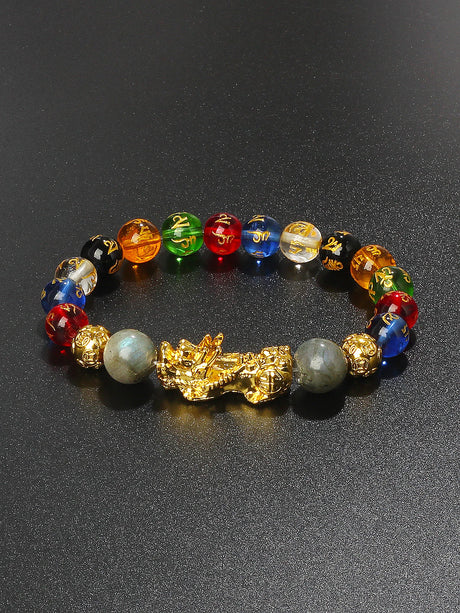 Colorful beaded bracelet with a gold dragon charm on a black background