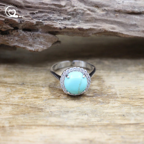 Turquoise ring with silver band on a wooden surface