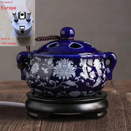 Blue ceramic incense burner with floral patterns on a wooden surface, with a plug adapter inset.