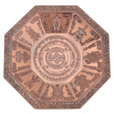 Decorative metal plate with intricate designs on a white background