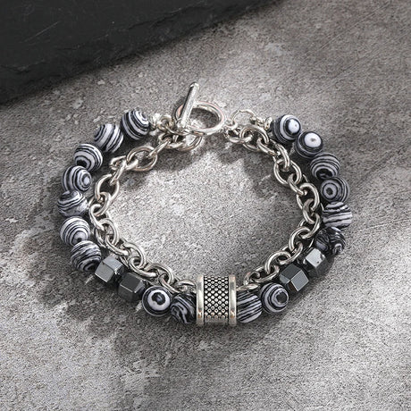 Silver bracelet with various beads on a stone surface