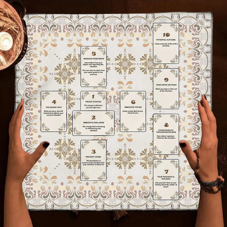 Card game with decorative cards on a patterned surface, held by two hands.