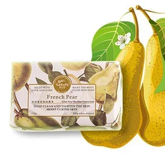 Bar of soap with French Pear packaging next to two pears on a white background