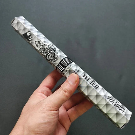 Hand holding a diamond-patterned vape pen against a dark background