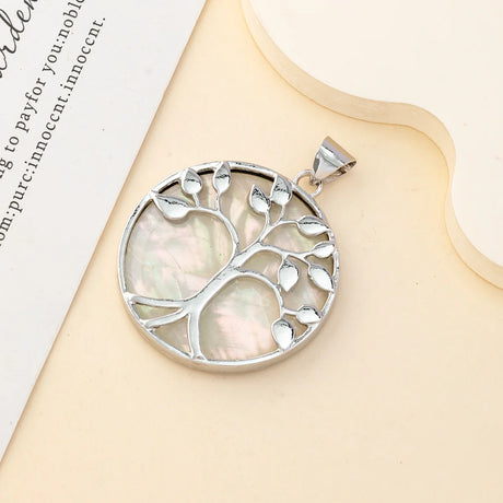 Silver tree of life pendant on a beige surface