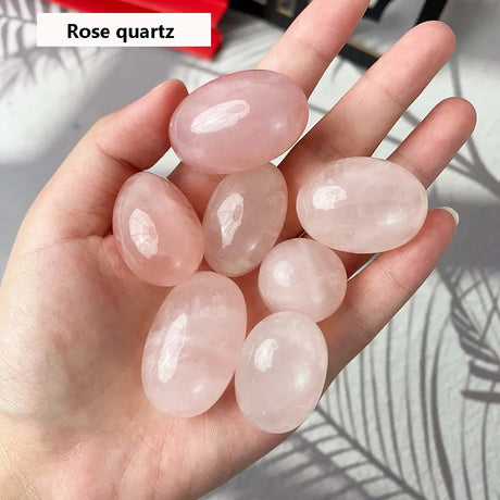 Hand holding pink rose quartz stones with a blurred background