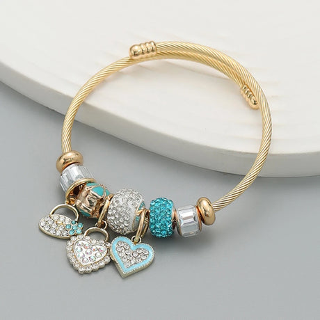 Gold bracelet with heart-shaped charms on a gray surface