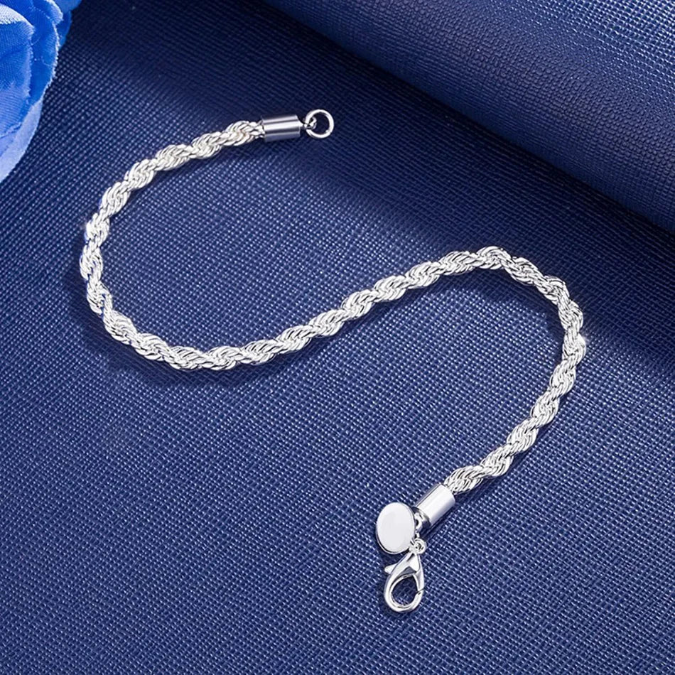 Silver braided bracelet on a blue fabric background