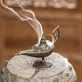 Decorative oil lamp with smoke on a stone surface