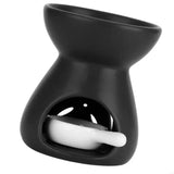Black wax warmer with a white candle on a white background