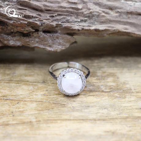 Silver ring with a gemstone on a wooden surface