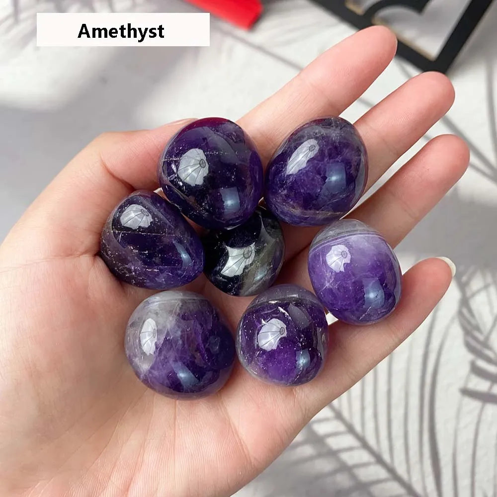 Hand holding purple amethyst crystals with a blurred background