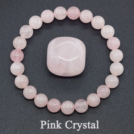 Pink crystal bracelet and stone on a dark background