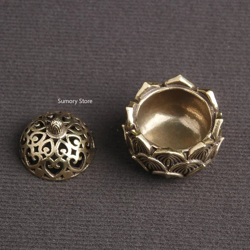 Two ornate brass lids on a gray background