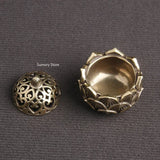 Two ornate brass lids on a gray background
