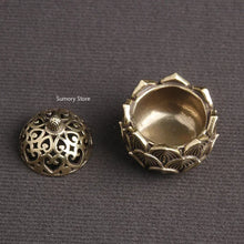 Two ornate brass lids on a gray background