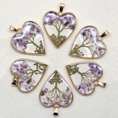 Set of heart-shaped pendants with floral designs on a light background