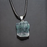 Necklace with a rough-cut gemstone pendant on a dark background