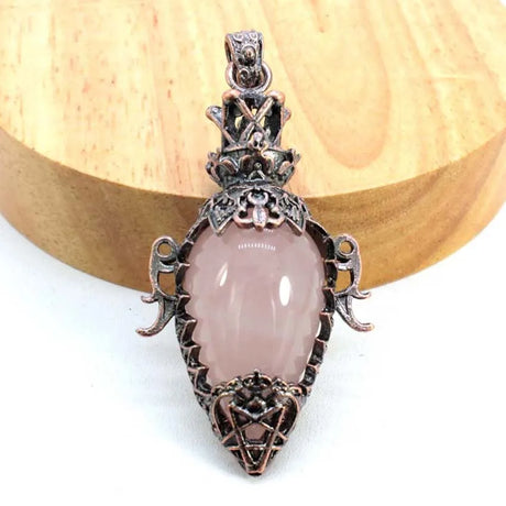 Pink stone pendant with silver decorative frame on a white background