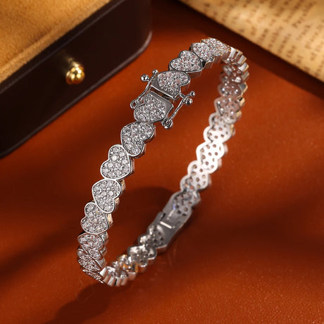 Silver bracelet with heart-shaped stones on a brown surface