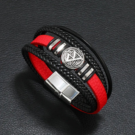 Black and red braided bracelet with a silver clasp on a dark textured background
