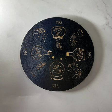 Black circular board with gold symbols and 'YES' and 'NO' options on a white marble surface.